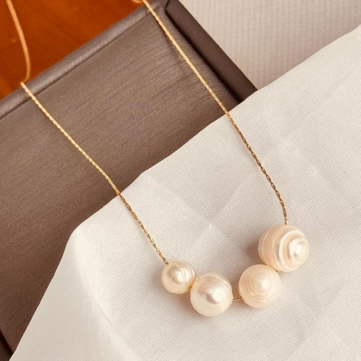 collier doré avec pendentif en perle blanche