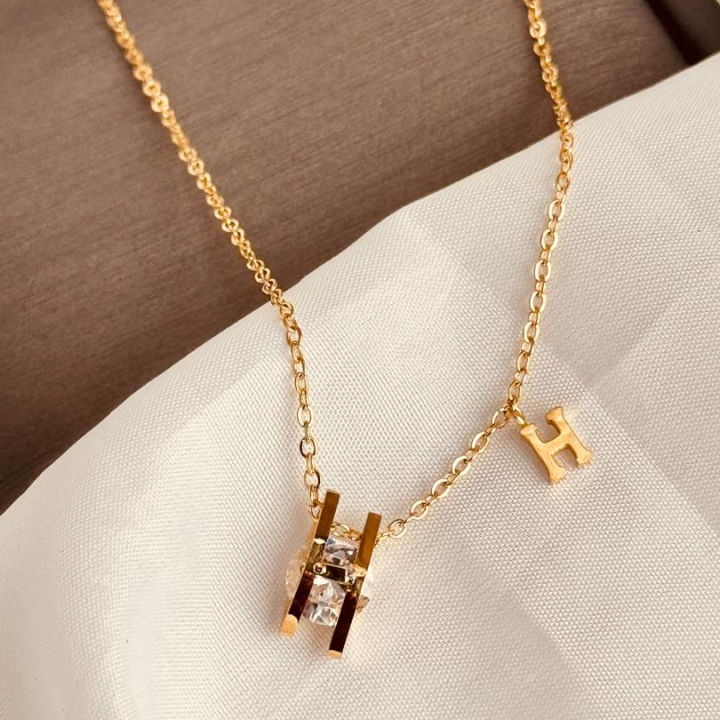 collier doré avec pendentif en H
